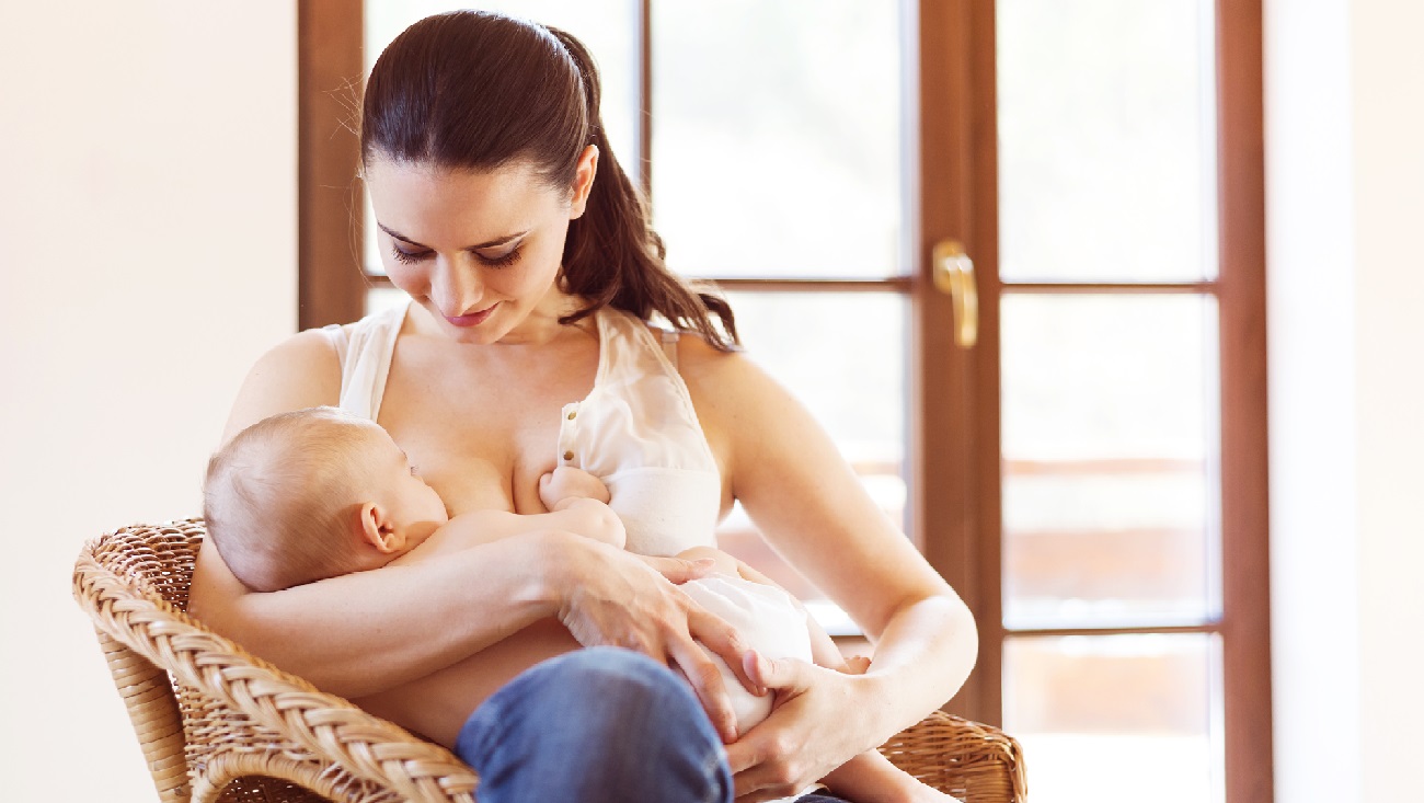 Крупным планом портрет ребенка сосать молоко из груди своей матери. | Премиум Фото